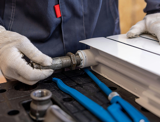 Persona con guantes instalando o reparando una tubería en un sistema de fontanería